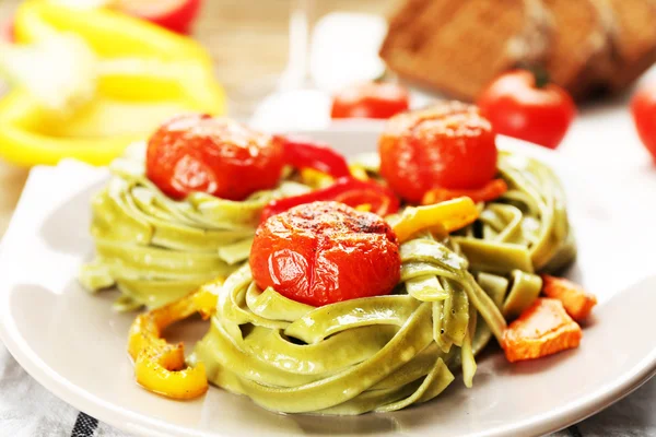 Pâtes savoureuses au poivre, carotte et tomates sur fond de table en bois — Photo