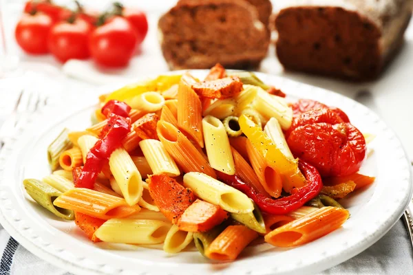 Nudelsalat mit Paprika, Karotten und Tomaten auf Holztischhintergrund — Stockfoto