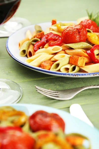 Pastasalade met peper, wortel en tomaten op houten tafel achtergrond — Stockfoto