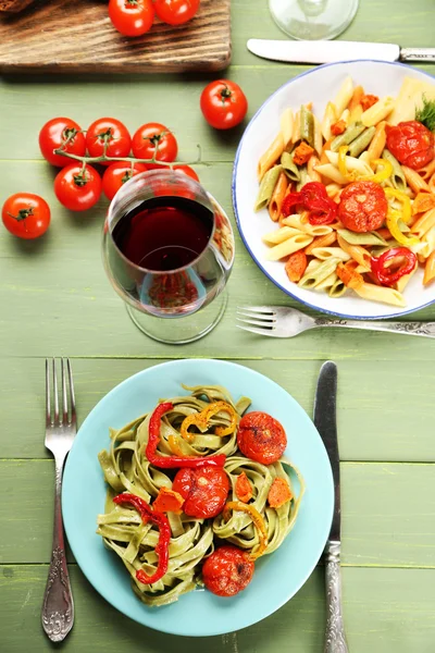 Tasty pasta with pepper, carrot and tomatoes on wooden table background — Stock Photo, Image