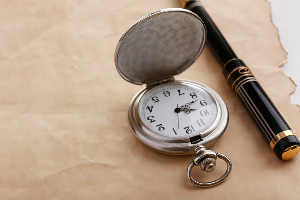 Reloj de bolsillo de plata sobre fondo de papel viejo —  Fotos de Stock