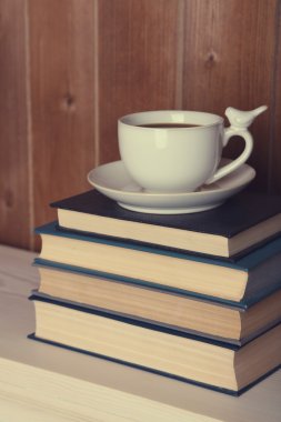 Yığın masa üstü ve ahşap arka plan üzerinde Kupası ile kitap