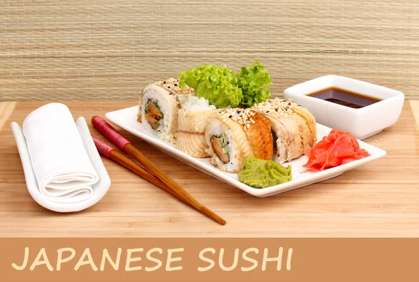 Delicious rolls served on plate on bamboo mat with space for your text — Stock Photo, Image