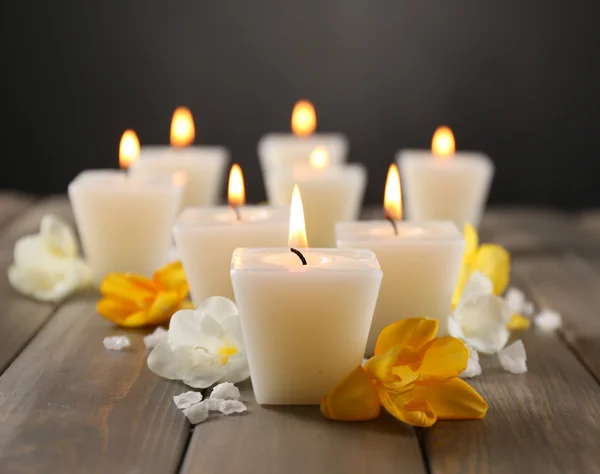 Belas velas com flores no fundo de madeira — Fotografia de Stock