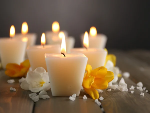 Belas velas com flores no fundo de madeira — Fotografia de Stock