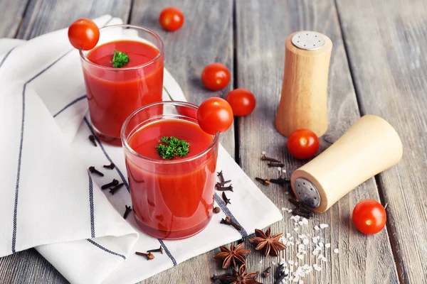 Jugo de tomate en vasos y verduras frescas en servilleta sobre fondo de madera —  Fotos de Stock