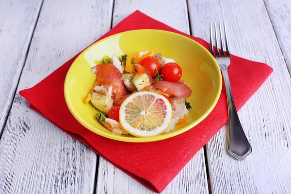 Ensalada de pescado fresco con verduras en plato sobre mesa de madera de cerca — Foto de Stock