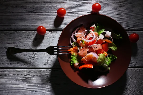 Ensalada de pescado fresco con verduras en plato sobre mesa de madera de cerca — Foto de Stock
