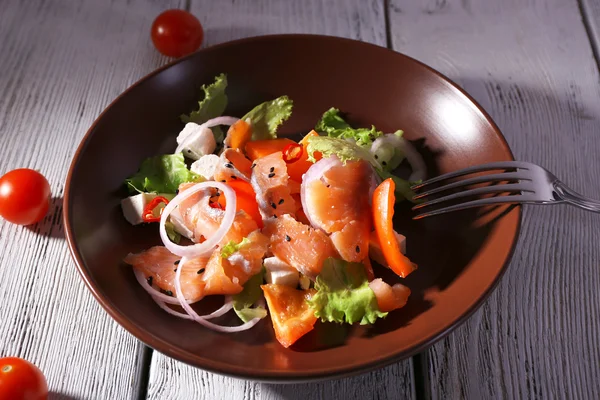 Ensalada de pescado fresco con verduras en plato sobre mesa de madera de cerca — Foto de Stock