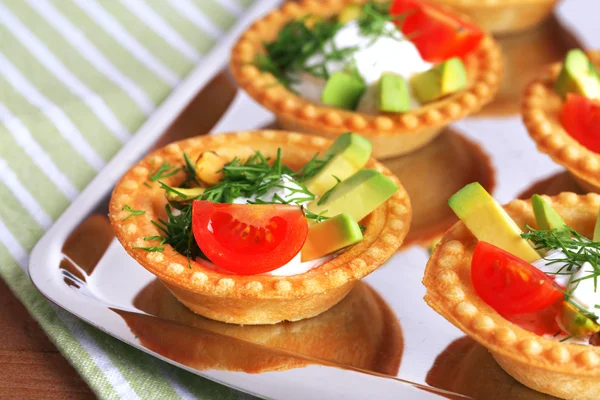 Tartlets with greens and vegetables with sauce on tray close-up — Stock Photo, Image