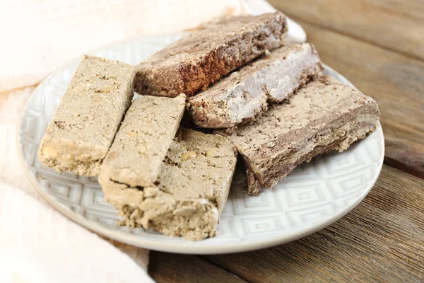 Two kinds of sunflower halva on plate, on wooden background — Stock Photo, Image