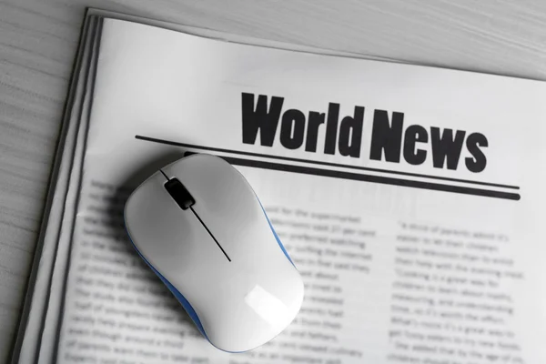 On-line news concept. Computer mouse and newspaper on wooden table background — Stock Photo, Image