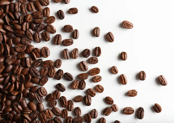 Kaffebönor på vitt bord, närbild — Stockfoto