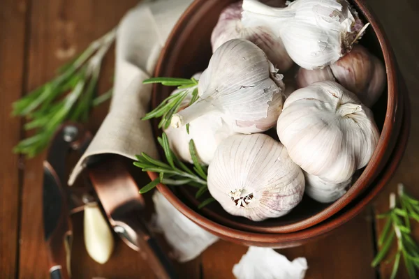 Rauwe knoflook en kruiden op houten tafel — Stockfoto