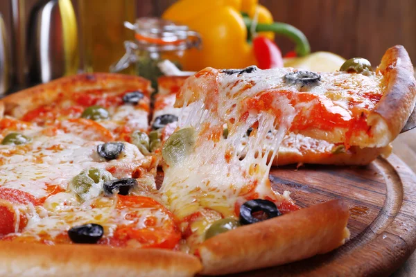 Пицца с сыром на борту и деревянный стол — стоковое фото