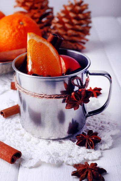 Dantel bardak altlığı peçete ile portakal üzerinde mulled şarap ve baharat renk ahşap arka plan üzerinde metal kupa — Stok fotoğraf