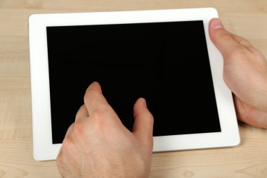 Tablet Pc kullanma ahşap masa arka plan üzerinde eller