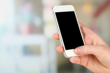 Akıllı cep telefonu hafif bulanık arka plan üzerinde tutan el
