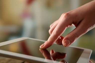 Ahşap masa ve ışık arka plan bulanık Tablet Pc kullanarak el