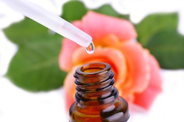 Damlalık şişe parfüm gül ışık arka plan üzerinde