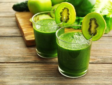 Meyve ve sebze kesme tahtası ve ahşap masa arka plan ile yeşil taze sağlıklı meyve suları