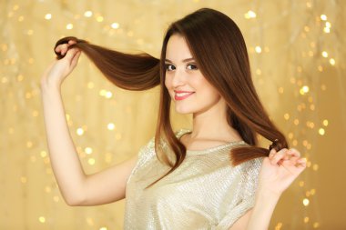 Parlak arka plan üzerinde uzun saçlı güzel genç kadın