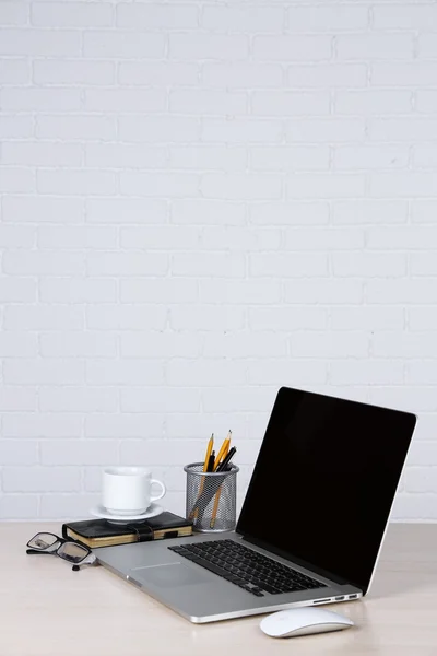 Moderne laptop op tafel, op witte muur achtergrond — Stockfoto