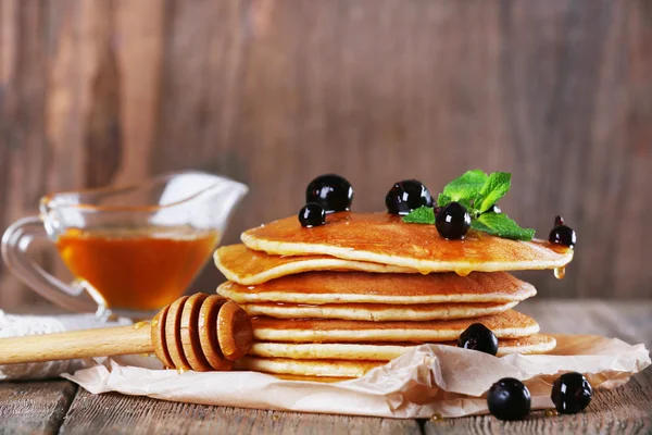 Stapel Pfannkuchen mit Minze und Beeren auf rustikalem Holzgrund — Stockfoto