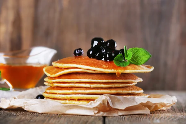 Stack of pancakes with mint and berries on rustic wooden background — Stock Photo, Image