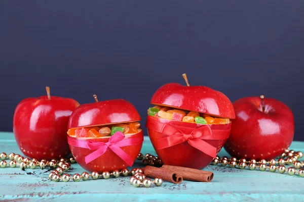 Kerstmis rode appels gevuld met gedroogde vruchten op kleur houten tafel en donkere achtergrond — Stockfoto