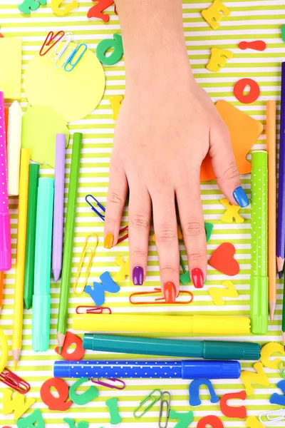 Multicolor female manicure with stationery on bright background — Stock Photo, Image