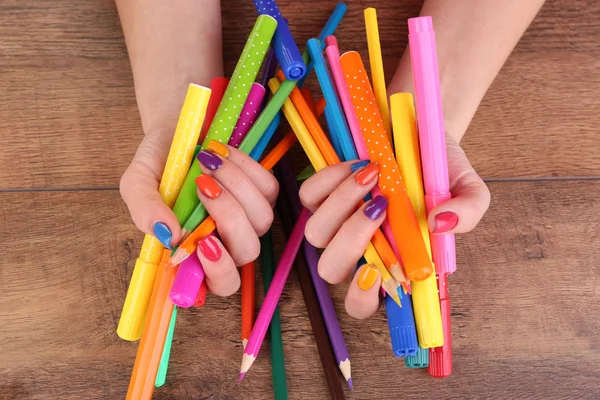 Multicolor manicure feminina com marcadores e lápis sobre fundo de madeira — Fotografia de Stock