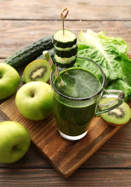 Groene vers gezond SAP met groenten en fruit op snijplank en houten tafel achtergrond — Stockfoto