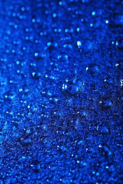 Gotas de agua sobre fondo de superficie de color, vista macro —  Fotos de Stock