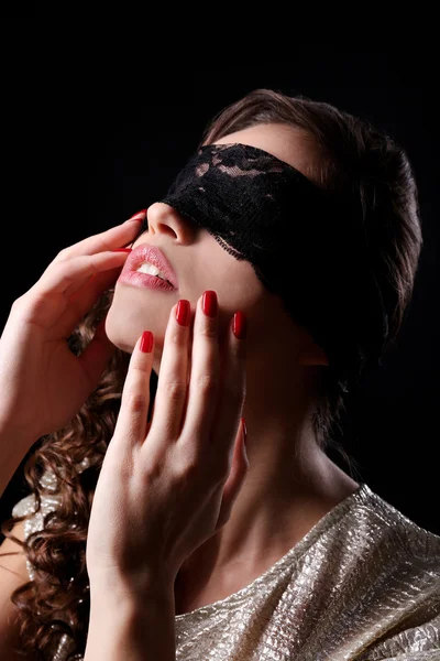 Menina bonita em máscara de renda sobre os olhos no fundo escuro — Fotografia de Stock