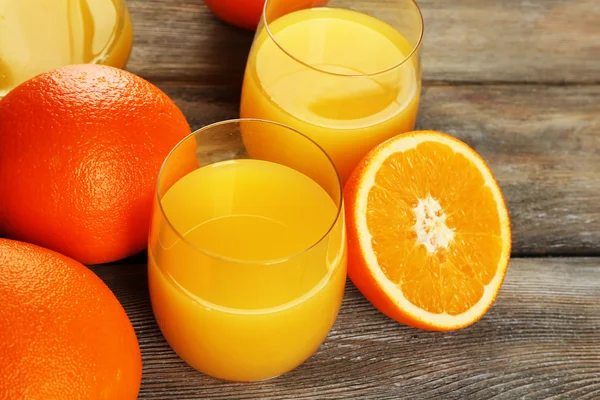 Copo de suco de laranja com fatias no fundo da mesa de madeira rústica — Fotografia de Stock