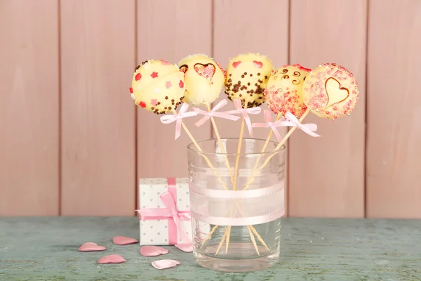 Tasty cake pops and gift on wooden background — Stock Photo, Image