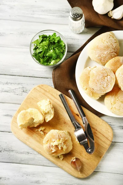 Čerstvý domácí chléb buchty z kynutého těsta na dřevěný tác, na barevné dřevěné pozadí — Stock fotografie
