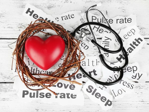 Decorative heart  with stethoscope on background of paper notes — Stock Photo, Image