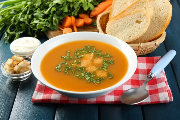 Složení s mrkvová polévka, ingredience a byliny na barevné dřevěné pozadí — Stock fotografie