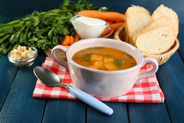 Composition with carrot soup, ingredients and herbs on color wooden background — Stock Photo, Image