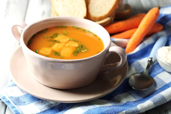 Soupe aux carottes, crème et cuillère, sur fond de bois couleur — Photo