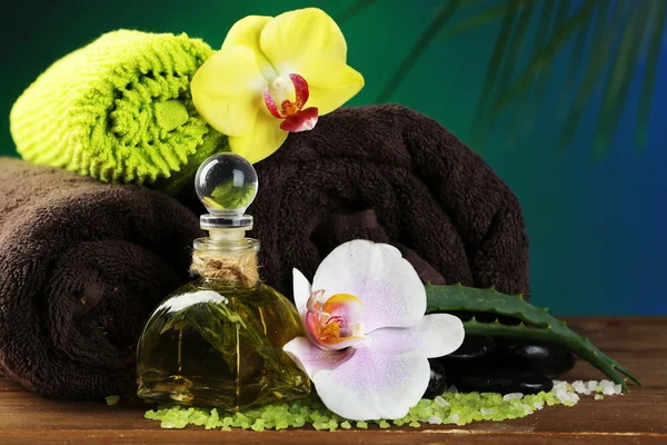 Spa-behandelingen met orchideebloemen op houten tafel op kleurrijke achtergrond — Stockfoto