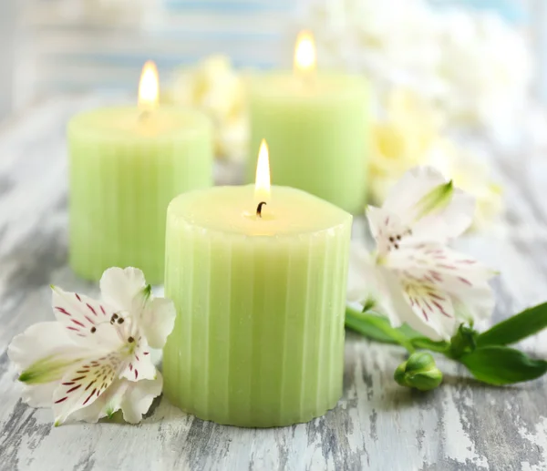 Hermosas velas con flores sobre fondo de madera — Foto de Stock