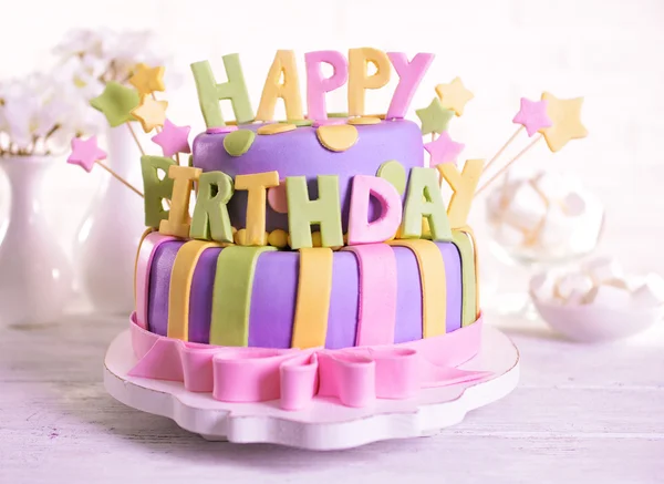 Delicioso pastel de cumpleaños en la mesa en el fondo de la pared de ladrillo —  Fotos de Stock