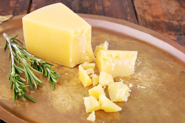 Brokkelt Parmezaanse kaas met takje rozemarijn op metalen lade op houten tafel achtergrond — Stockfoto
