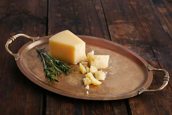 Crumbles fromage parmesan avec brin de romarin sur plateau métallique sur fond de table en bois — Photo