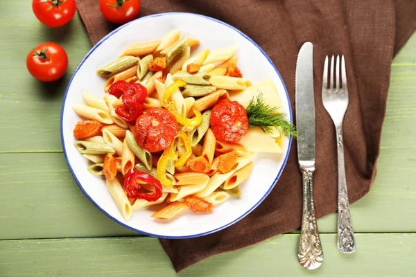 Pasta salad with pepper, carrot and tomatoes on wooden table background — Stock Photo, Image