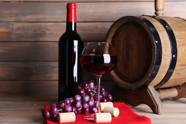 Červené víno na stole na dřevěné pozadí — Stock fotografie