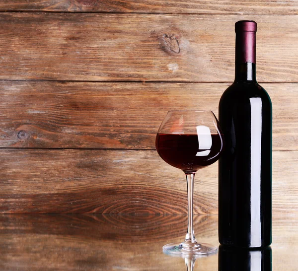 Vino tinto sobre mesa sobre fondo de madera — Foto de Stock